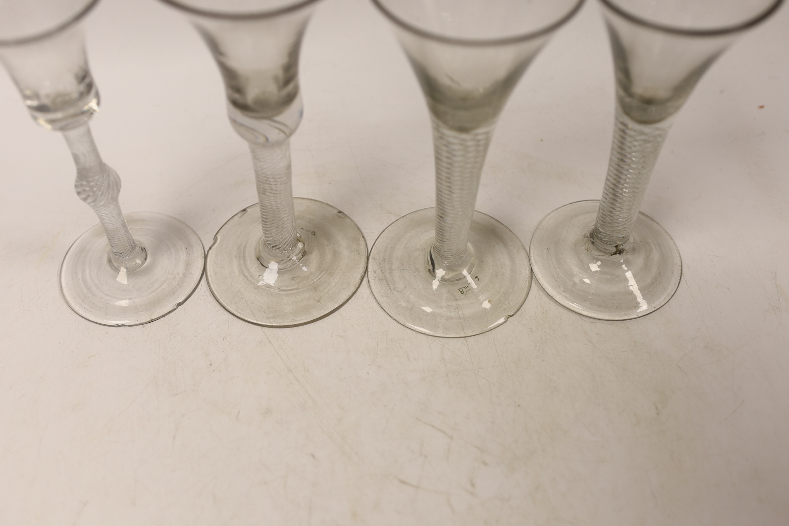 Four mid-18th century DSAT stem wine glasses, two drawn trumpet examples and two with bell shaped bowls, tallest 15.5cm